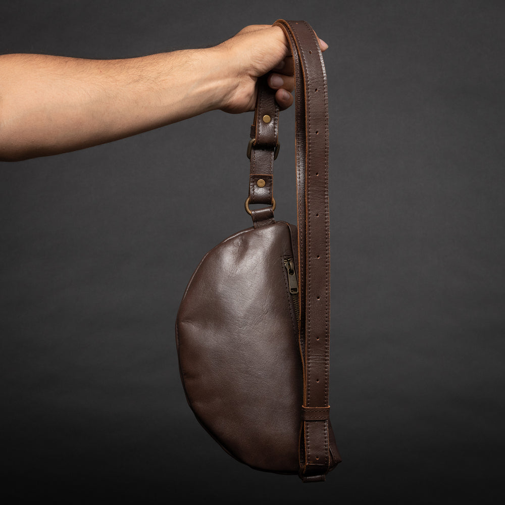 hand holding belt bag and showing the backside zipper pocket